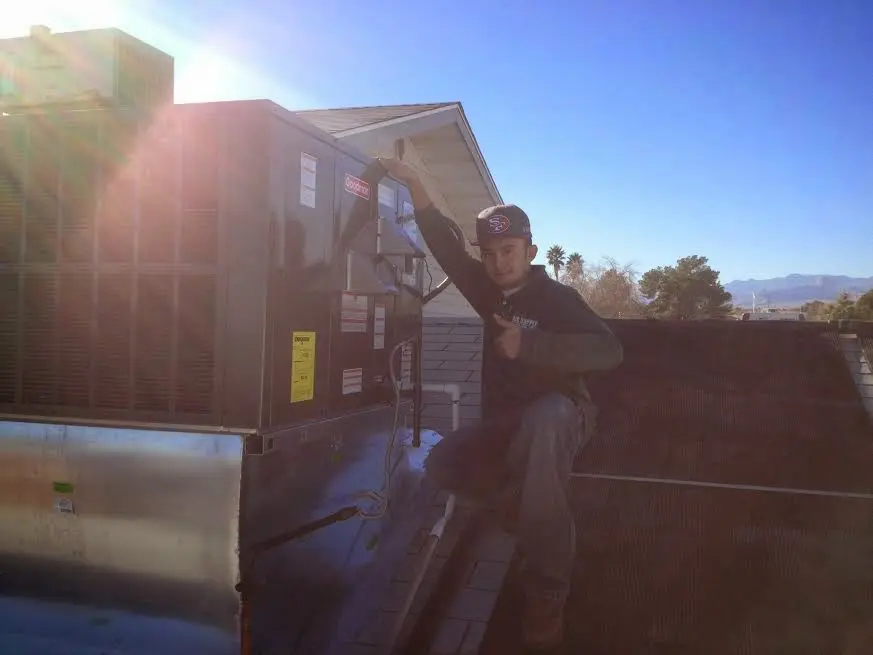 HVAC technician performing AC Tune-Up on a rooftop unit in St. Stephens
